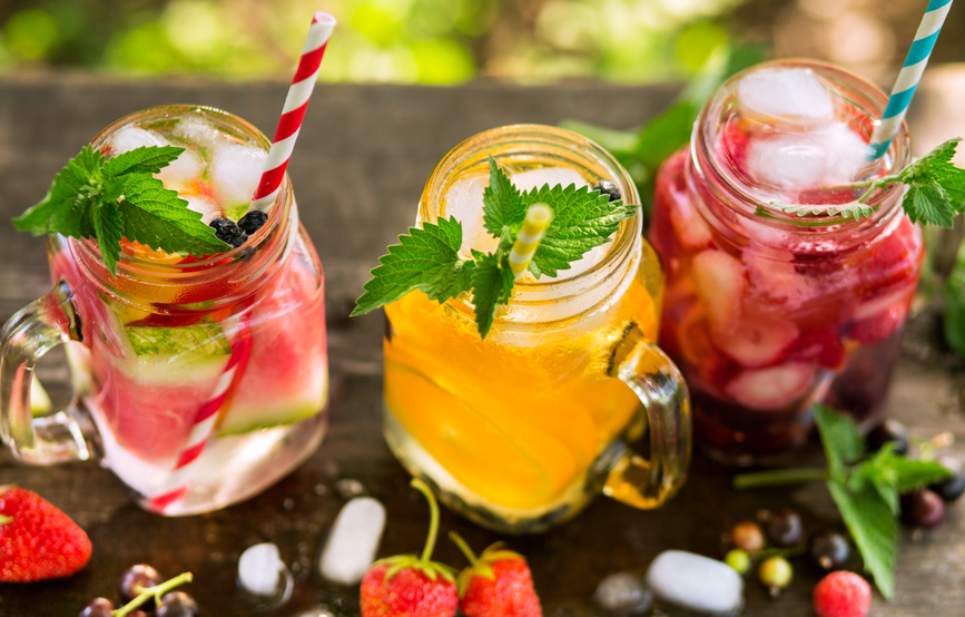 Refreshing drinks with ice in jars, orange juice, berry juice and watermelon water